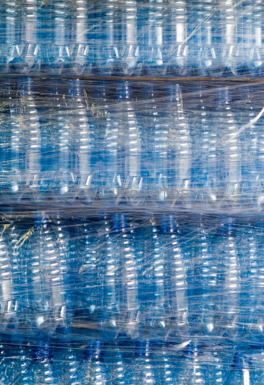 Plastic wrapping over finished water bottles in factory, warehouse industry