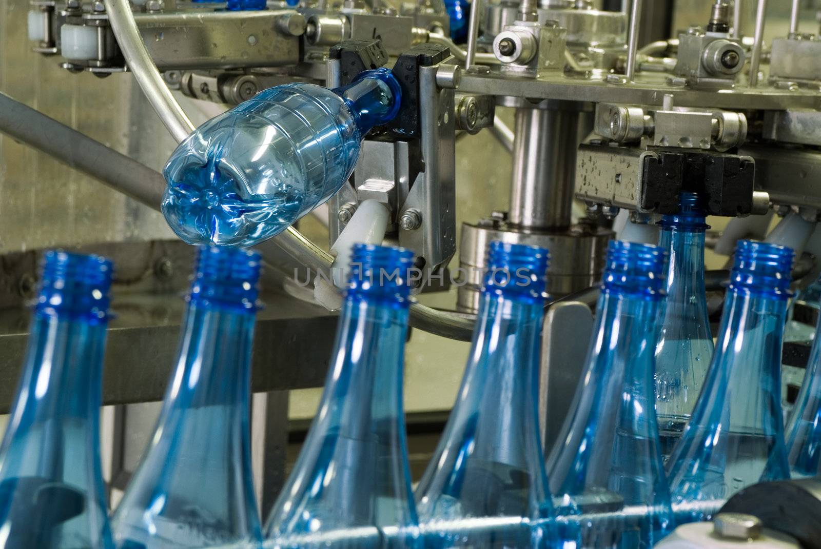 Plastic water bottles on conveyor or water bottling machine industry