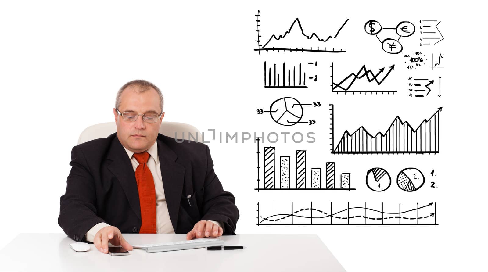 Businessman sitting at desk with diagrams and holding a mobilephone, isolated on white