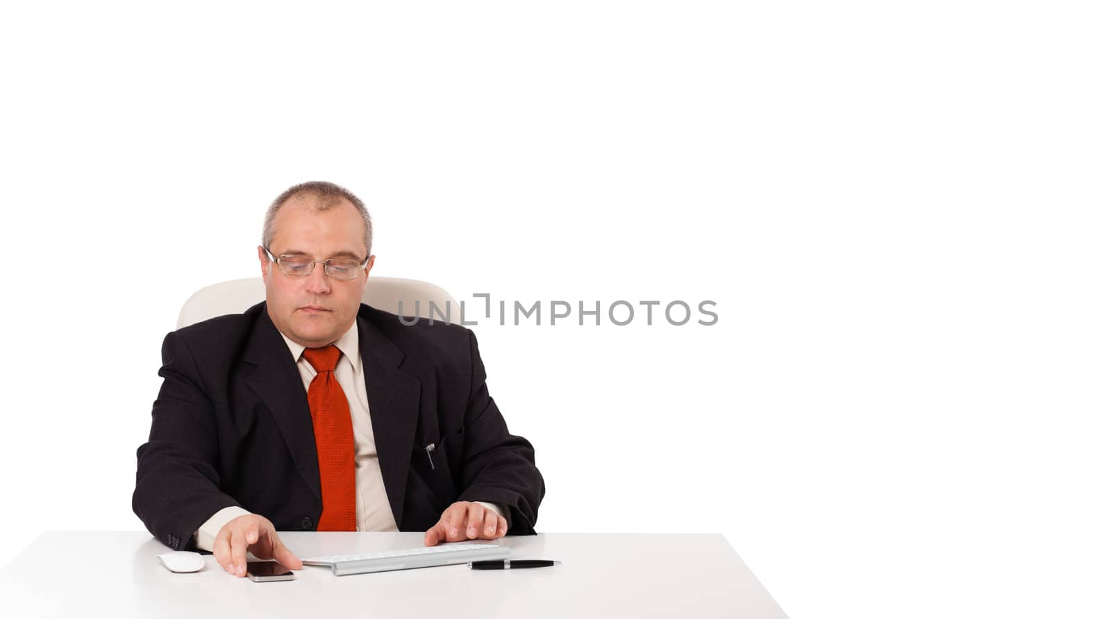 businessman sitting at desk and looking mobilephone with copyspace, isolated on white