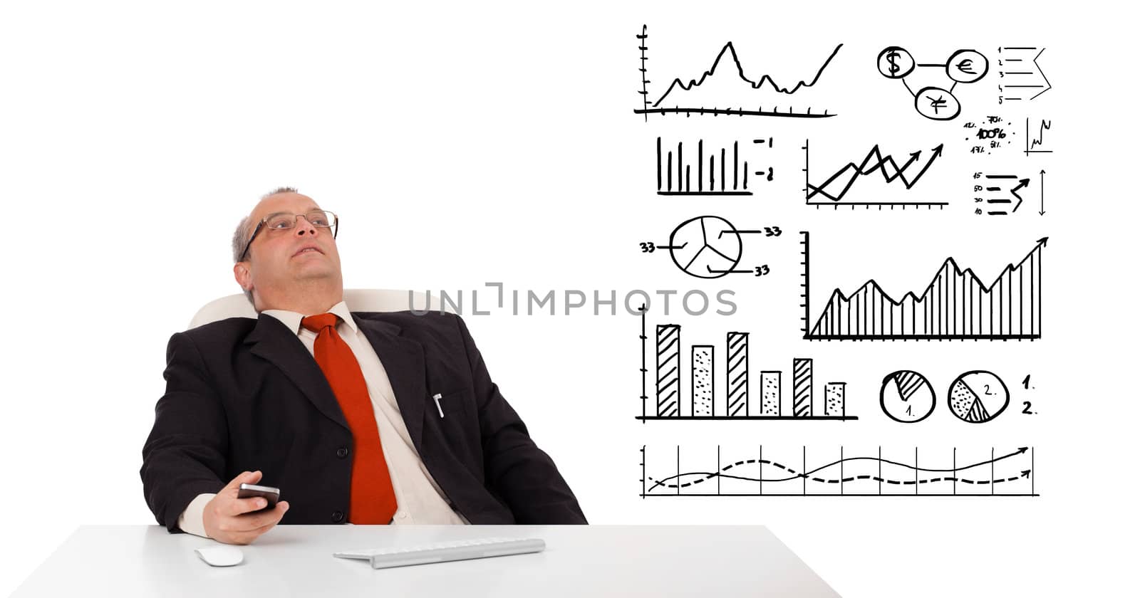 Businessman sitting at desk with diagrams and holding a mobilephone, isolated on white