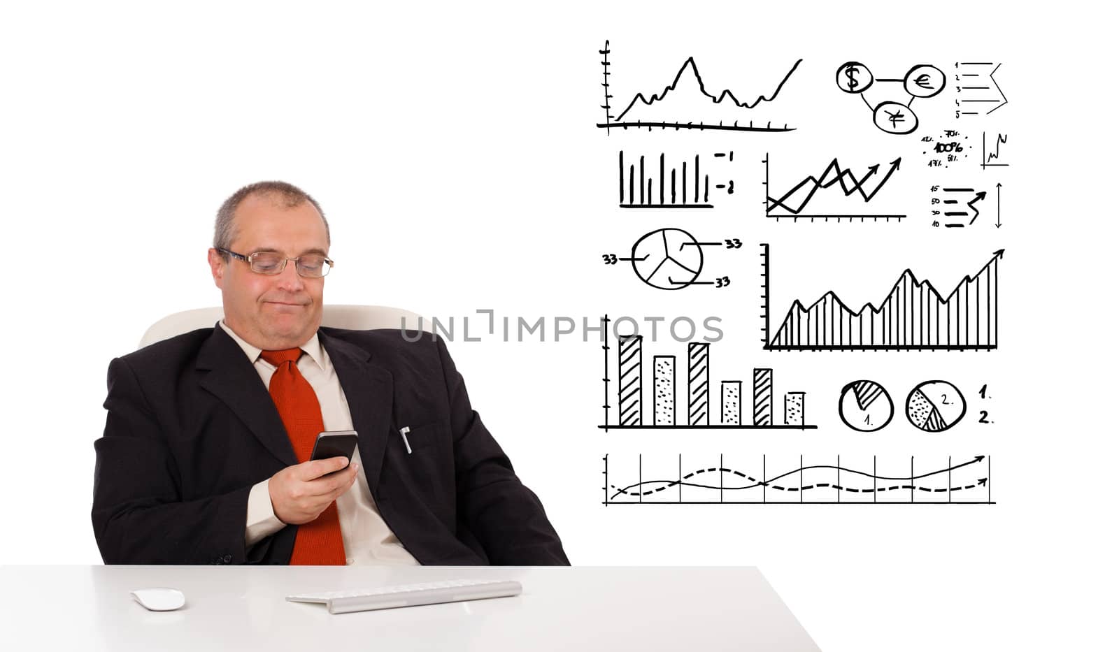 Businessman sitting at desk with diagrams and holding a mobilephone, isolated on white