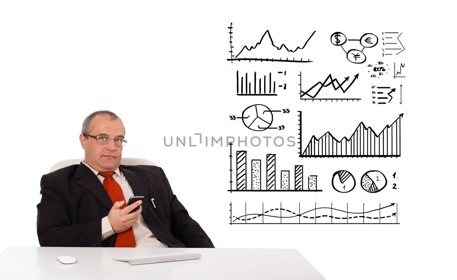 Businessman sitting at desk with diagrams and holding a mobilephone, isolated on white