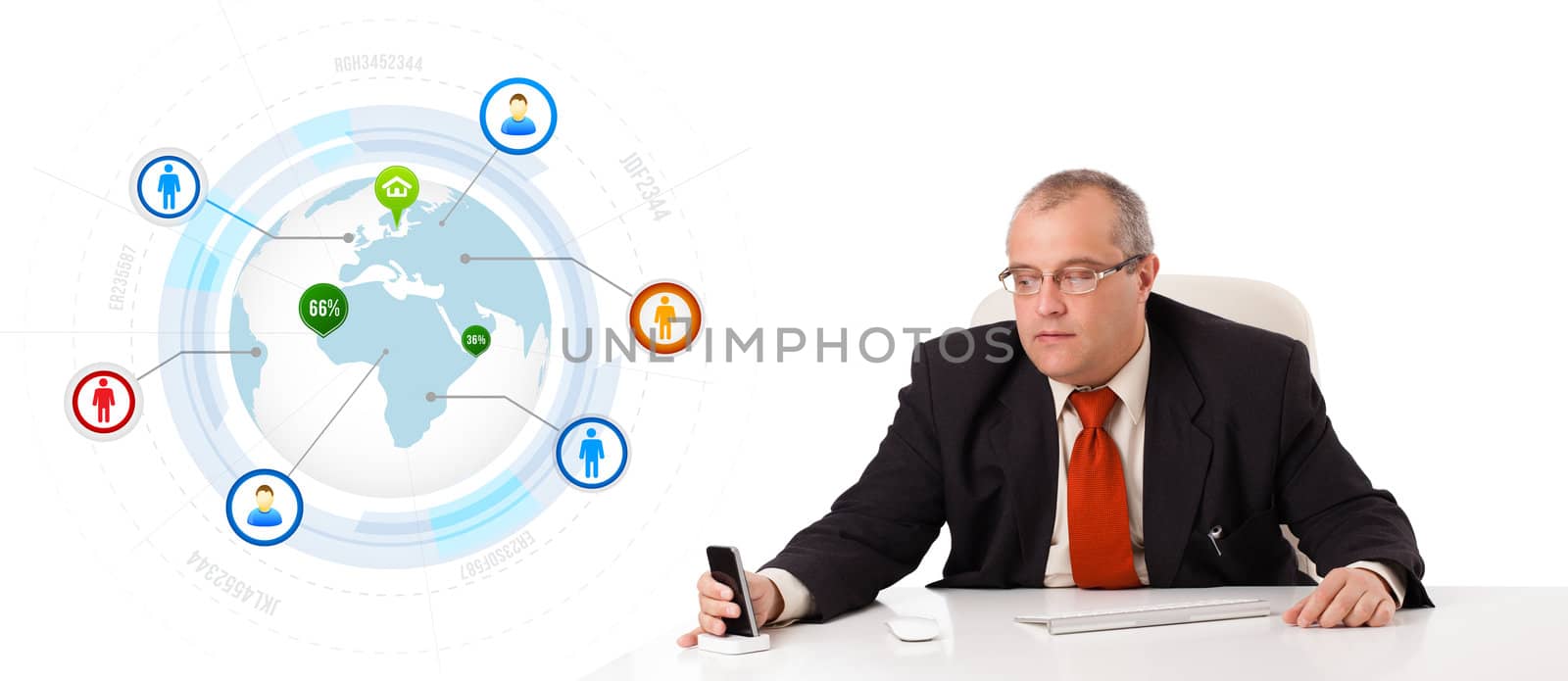 businessman sitting at desk and holding a mobilephone with globe and social icons, isolated on white