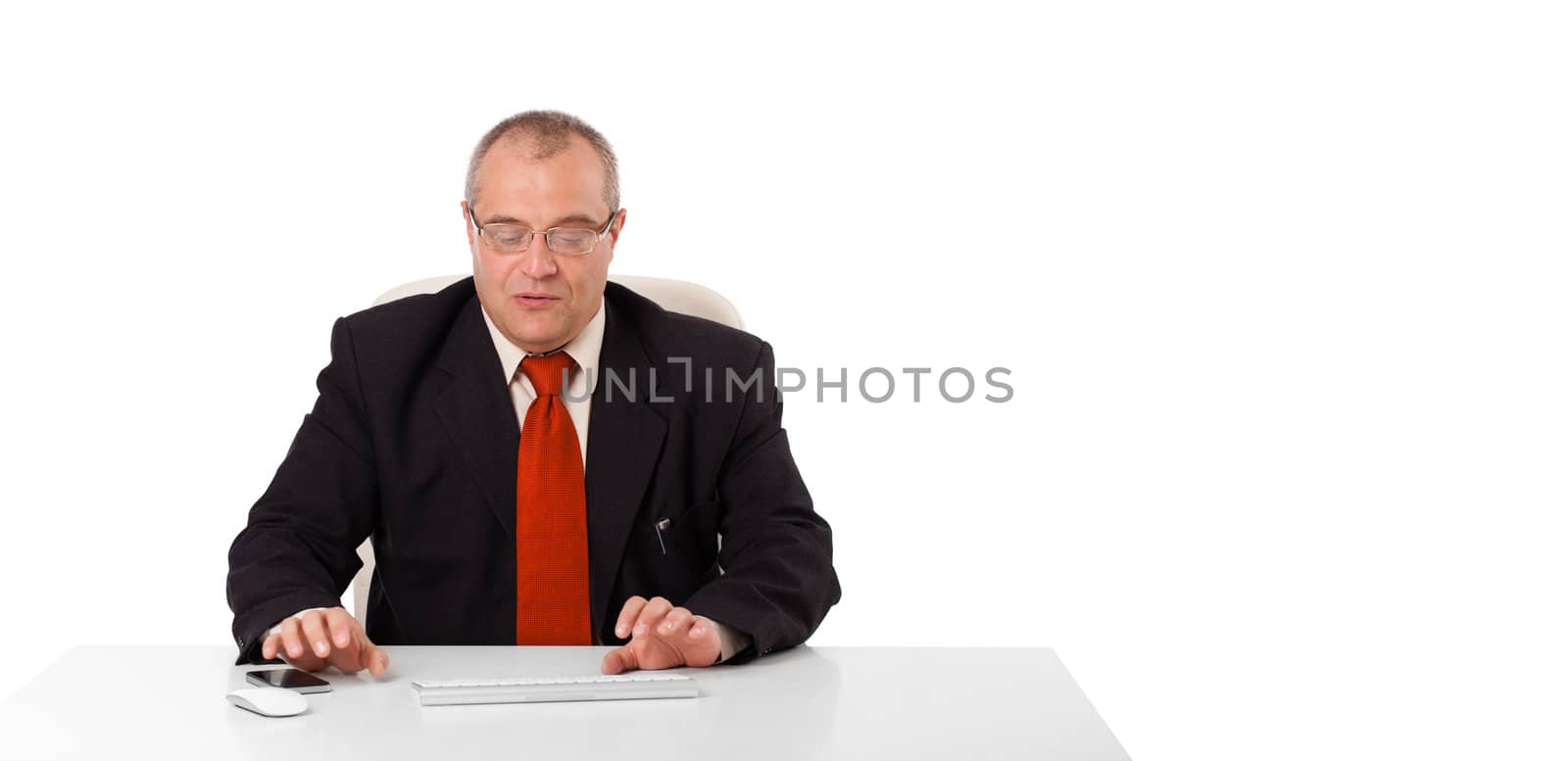 businessman sitting at desk and typing on keyboard with copy scape, isolated on white