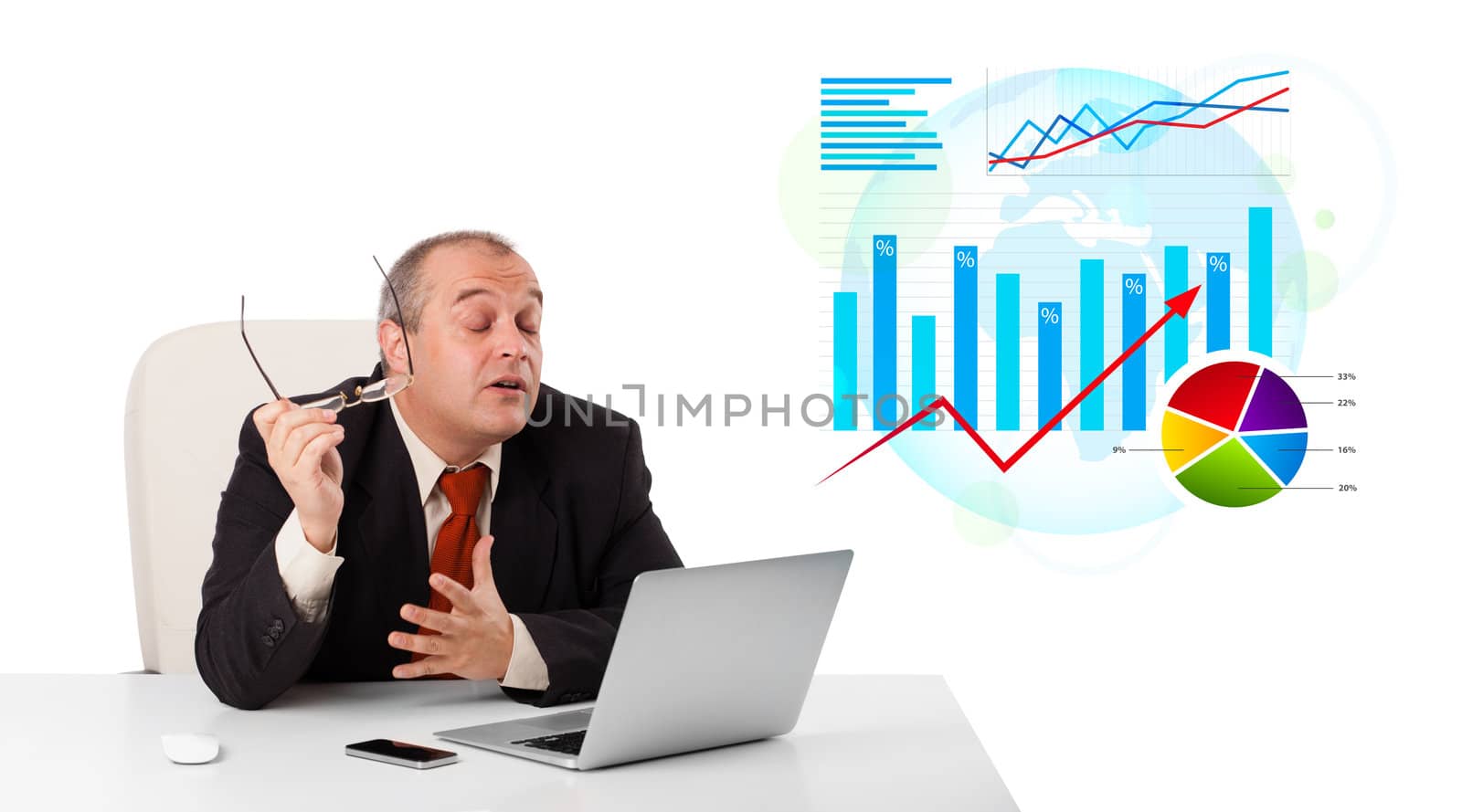 Businessman sitting at desk with laptop and statistics, isolated on white
