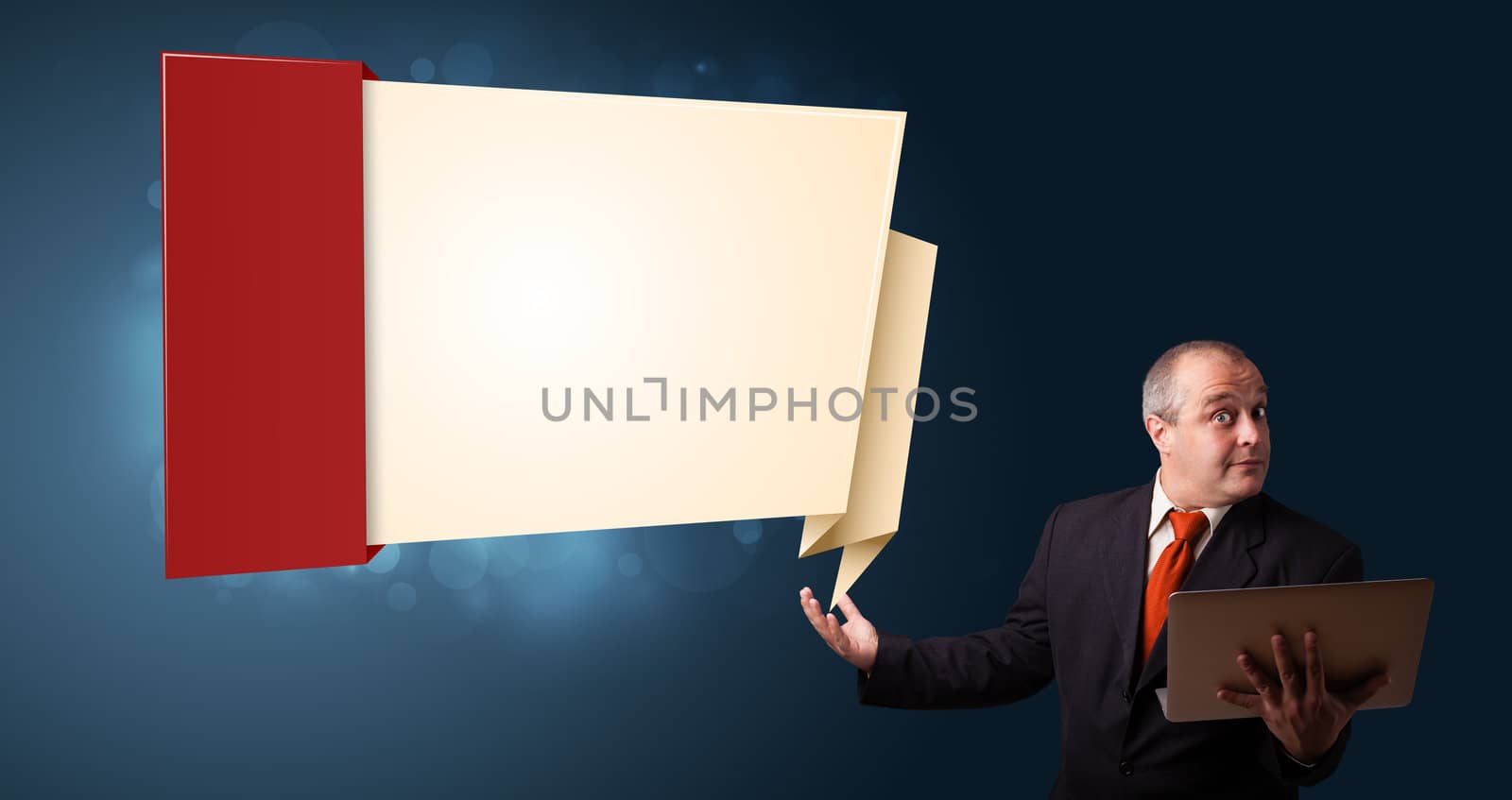 Businessman in suit holding a laptop and presenting modern origami copy space