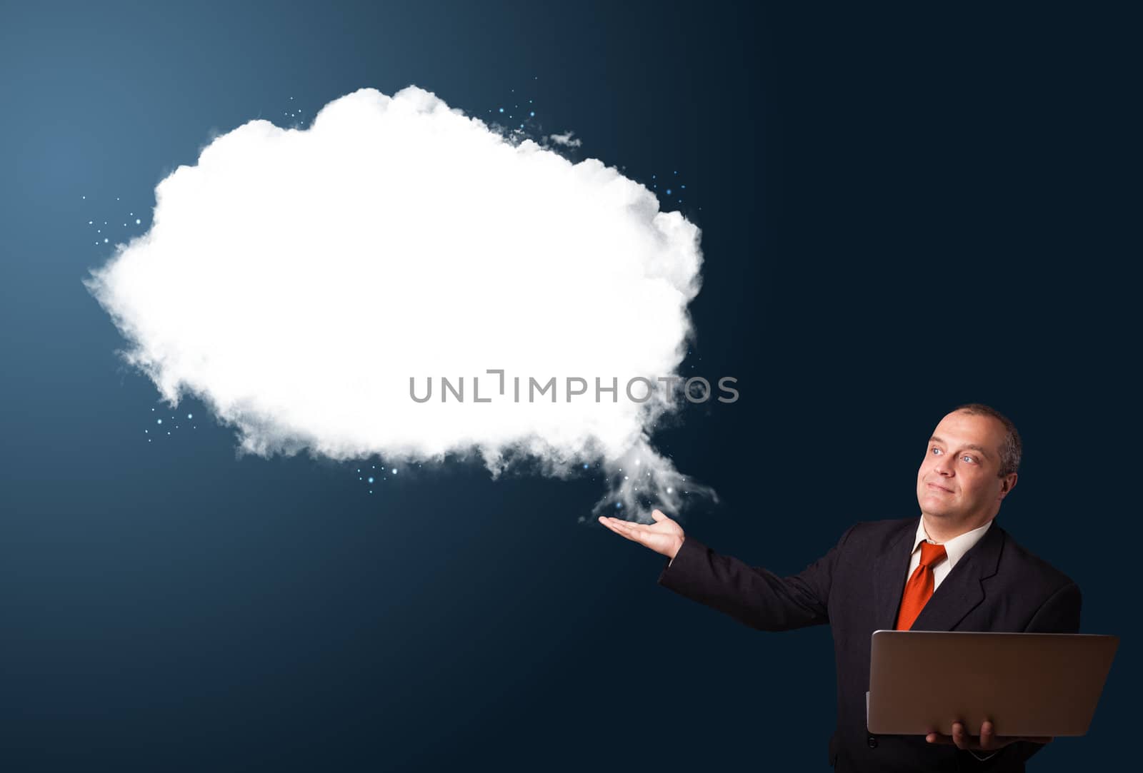 Businessman in suit holding a laptop and presenting abstract cloud copy space