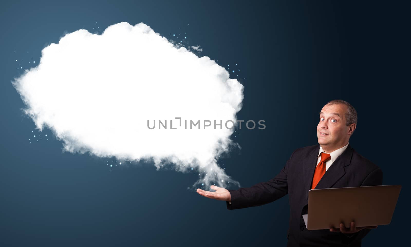 Businessman in suit holding a laptop and presenting abstract cloud copy space