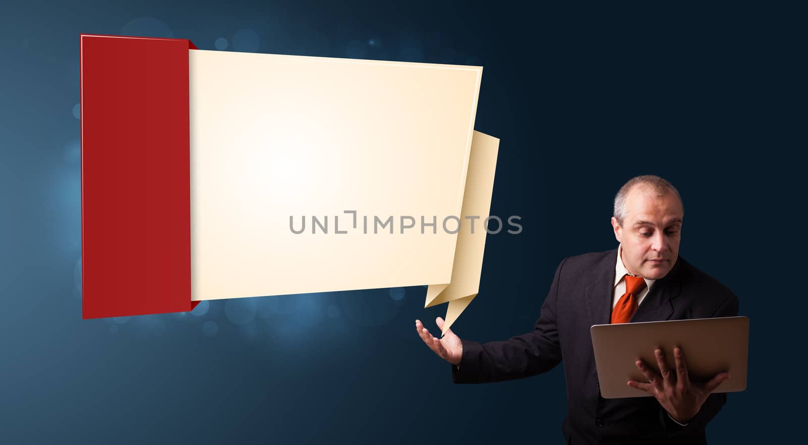 Businessman in suit holding a laptop and presenting modern origami copy space