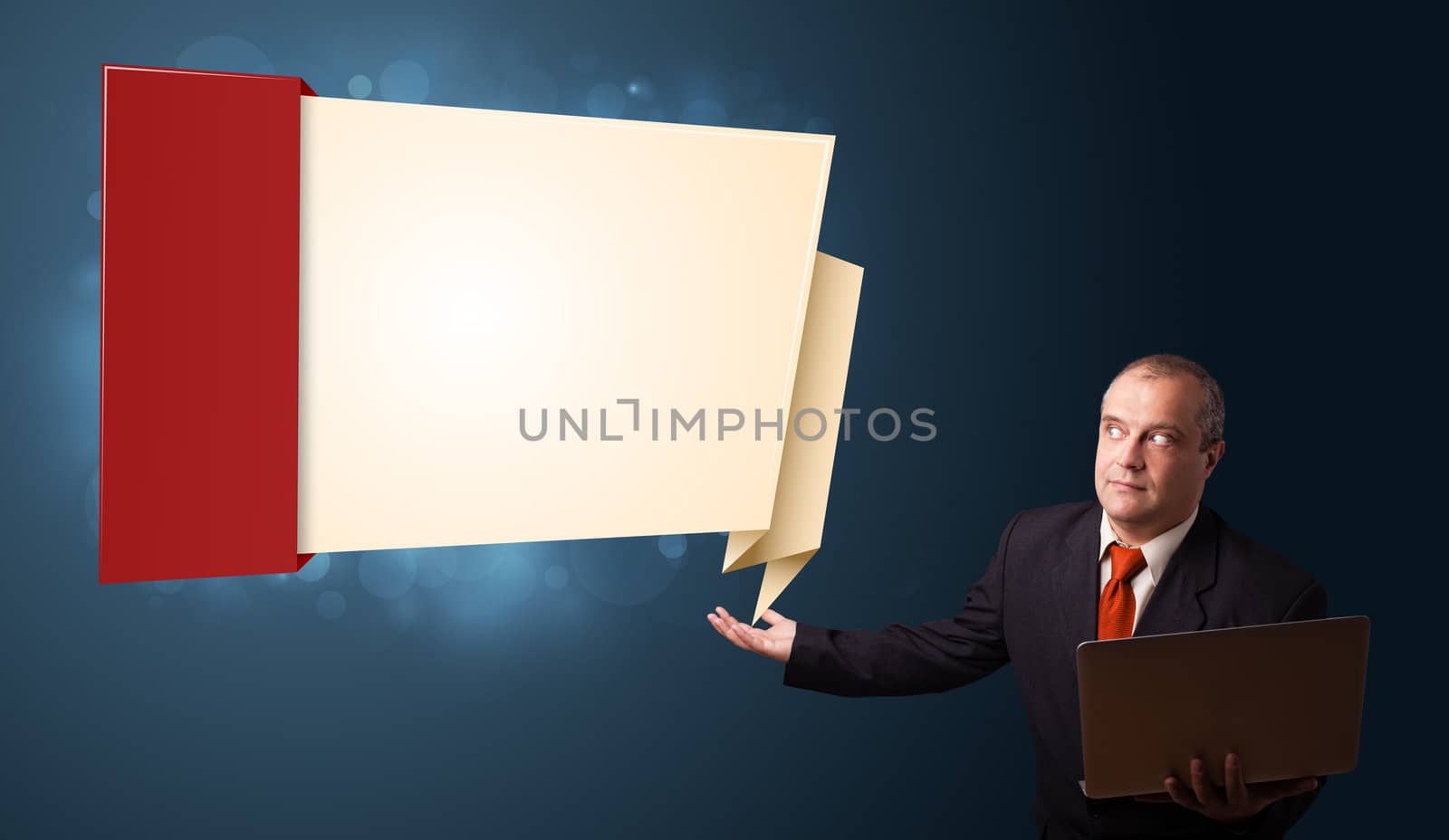 Businessman in suit holding a laptop and presenting modern origami copy space