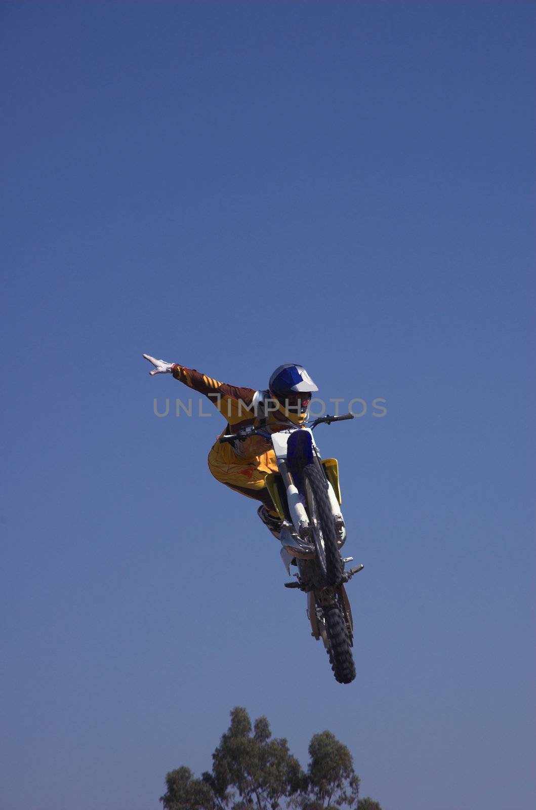 Moto X Freestyle rider high in sky with arms outstretched