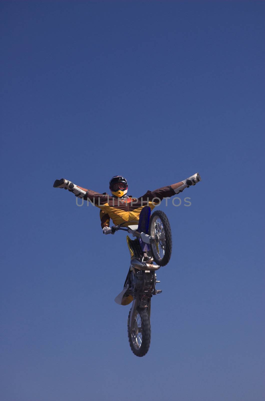 Moto X Freestyle rider with legs open trick high in sky
