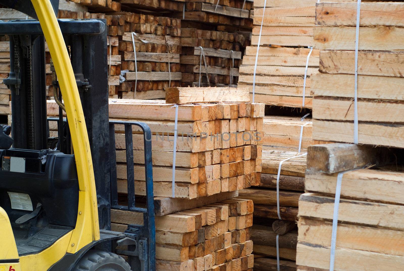 Yellow folk lift truck in wood factory or forestry timber depot