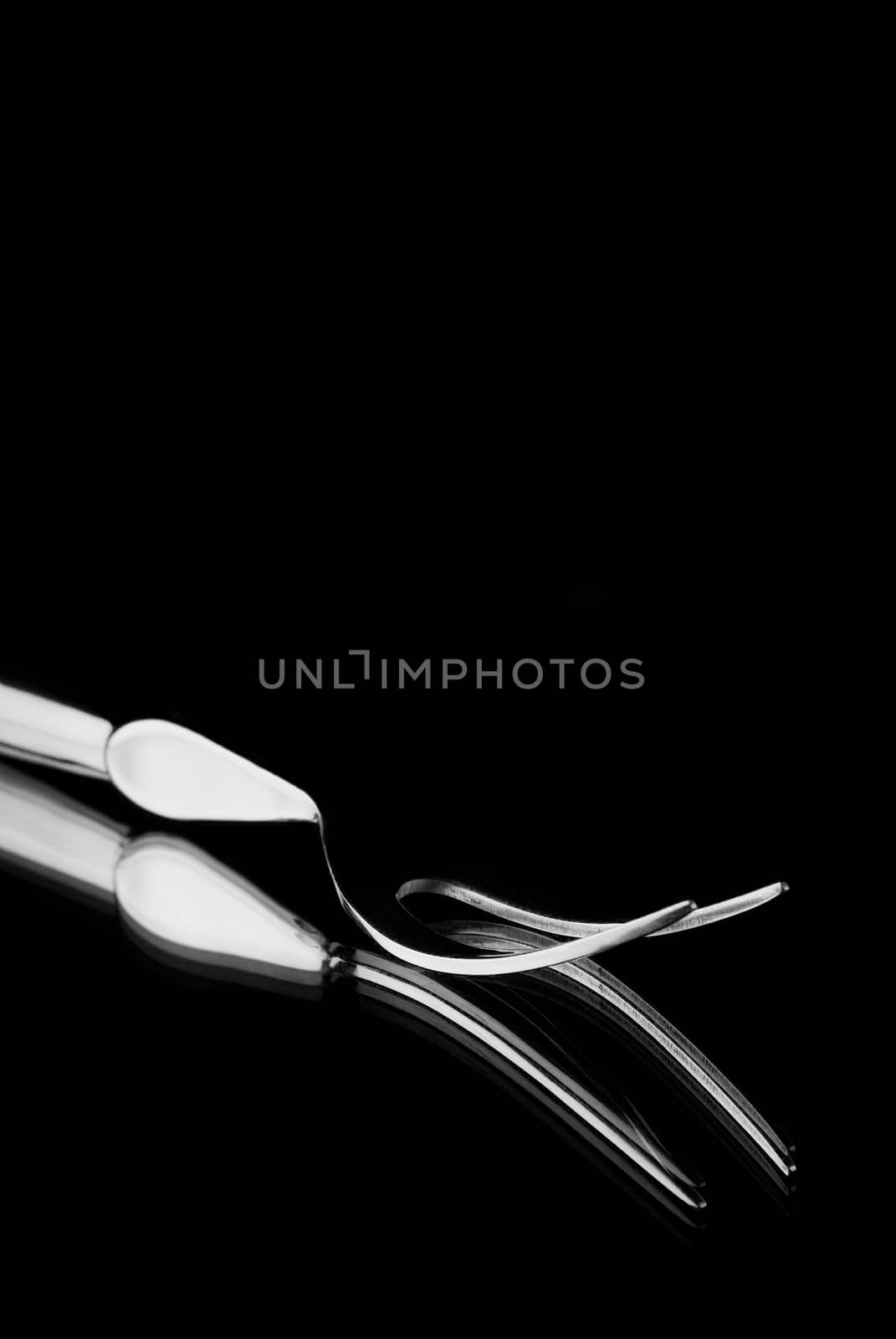 Single carving fork reflection on mirror with black background