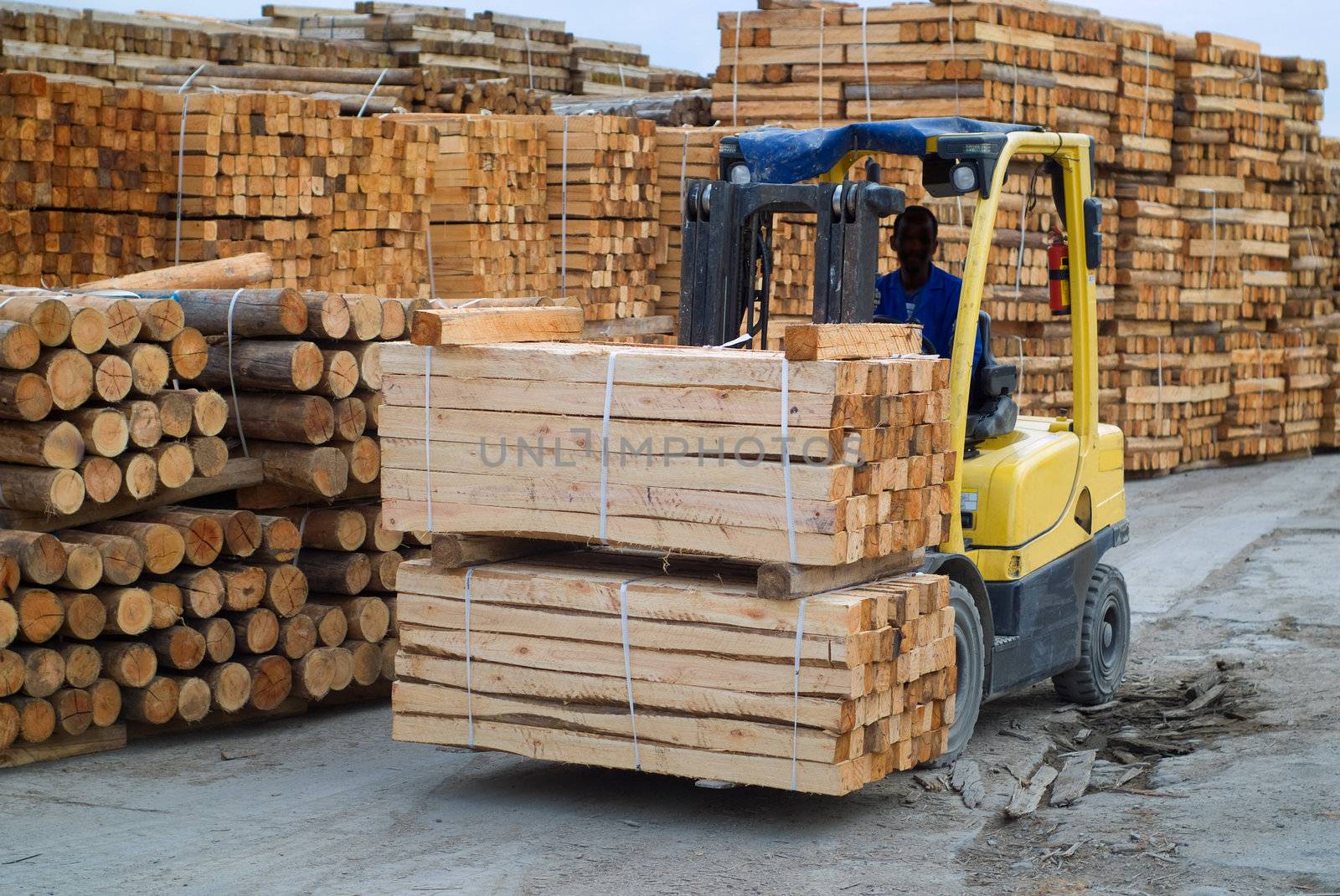 Yellow folk lift truck in wood factory or forestry timber depot