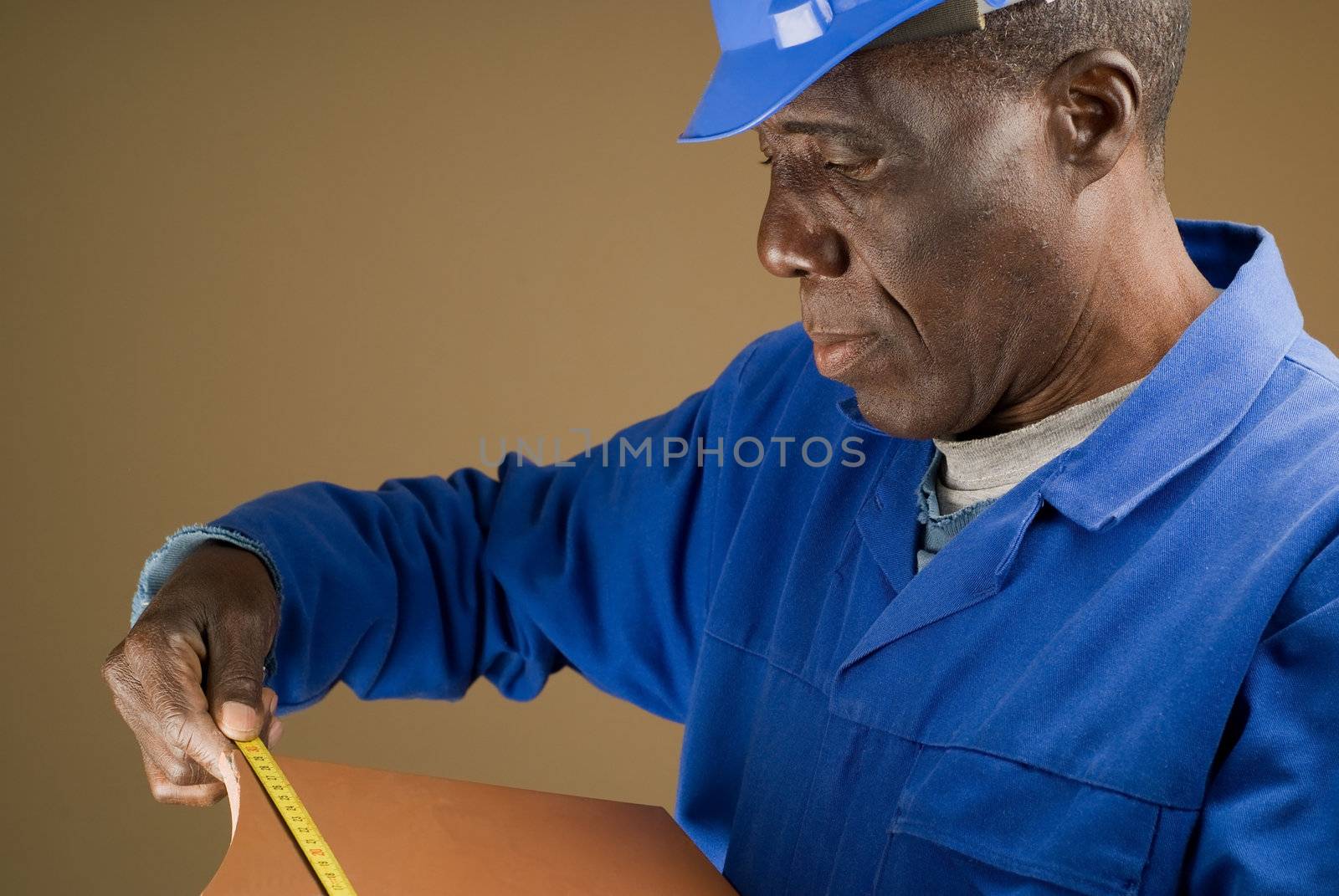 African American Construction Worker Measuring Tile with Measuring Tool