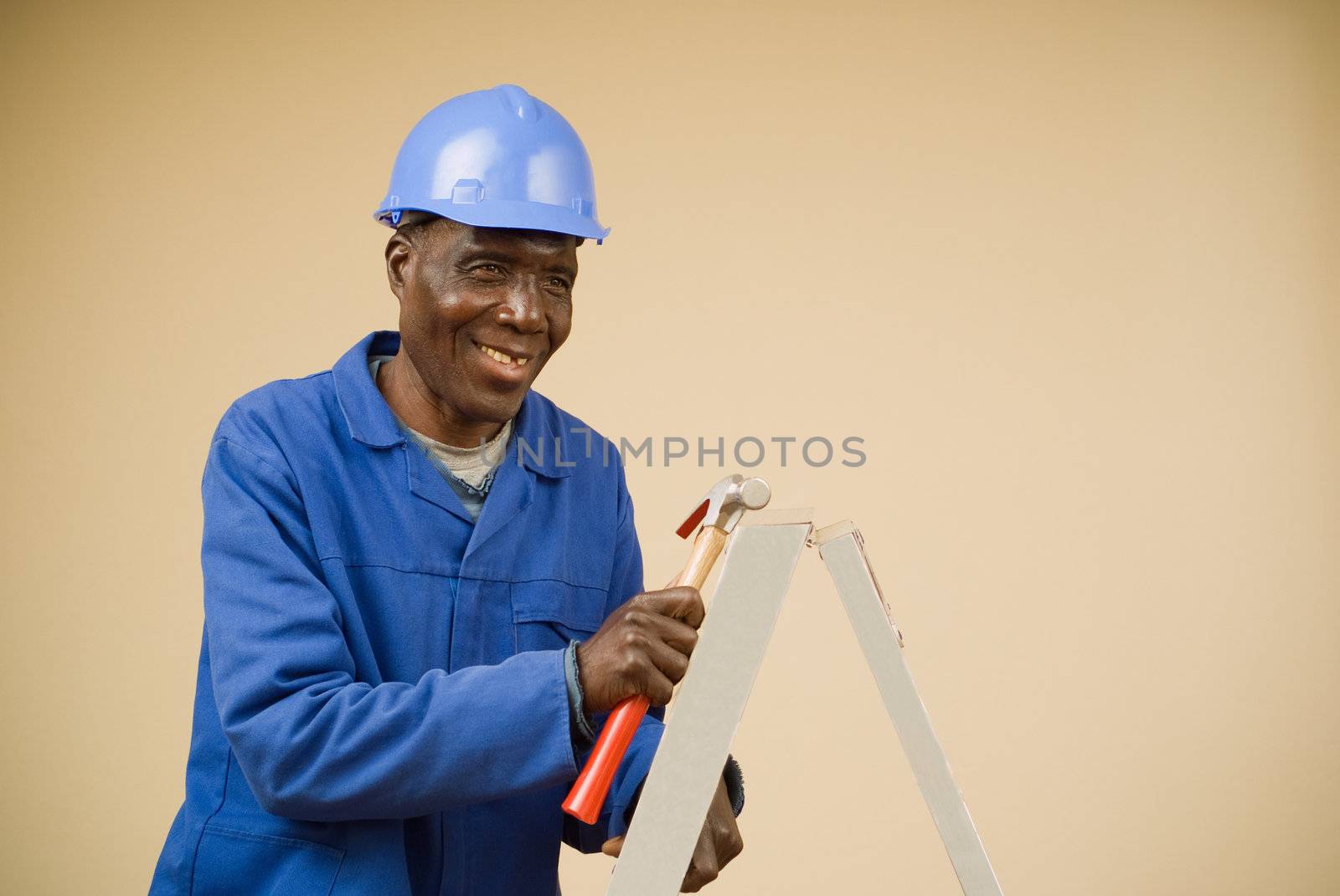 Construction worker holding hammer on ladder by alistaircotton