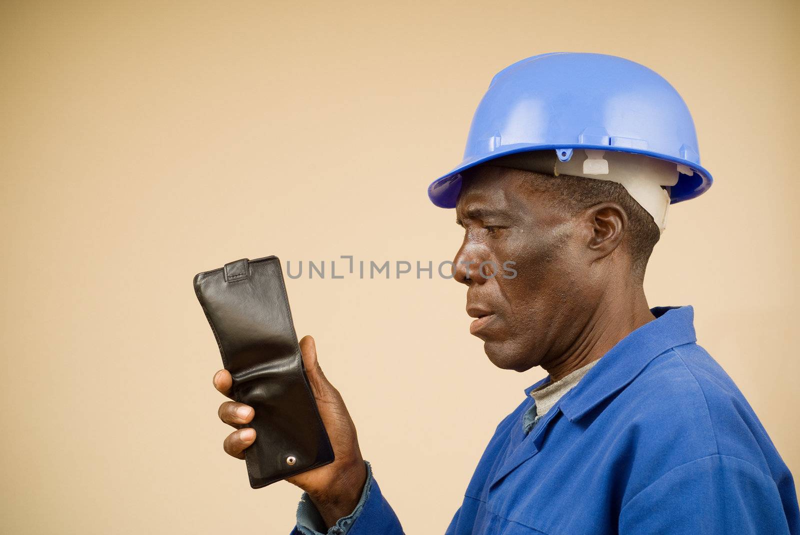 Portrait of construction worker staring at an empty wallet
