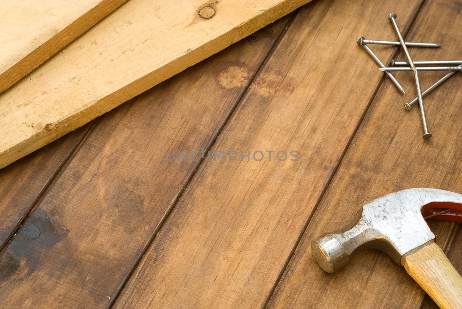 Hammer, nails and plank on table by alistaircotton