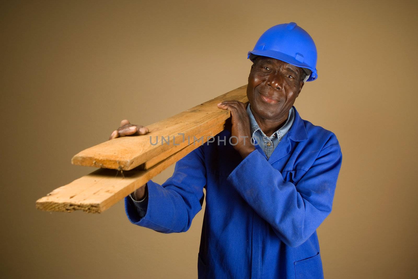 Senior South African or American plumber, carpenter or builder with wooden planks