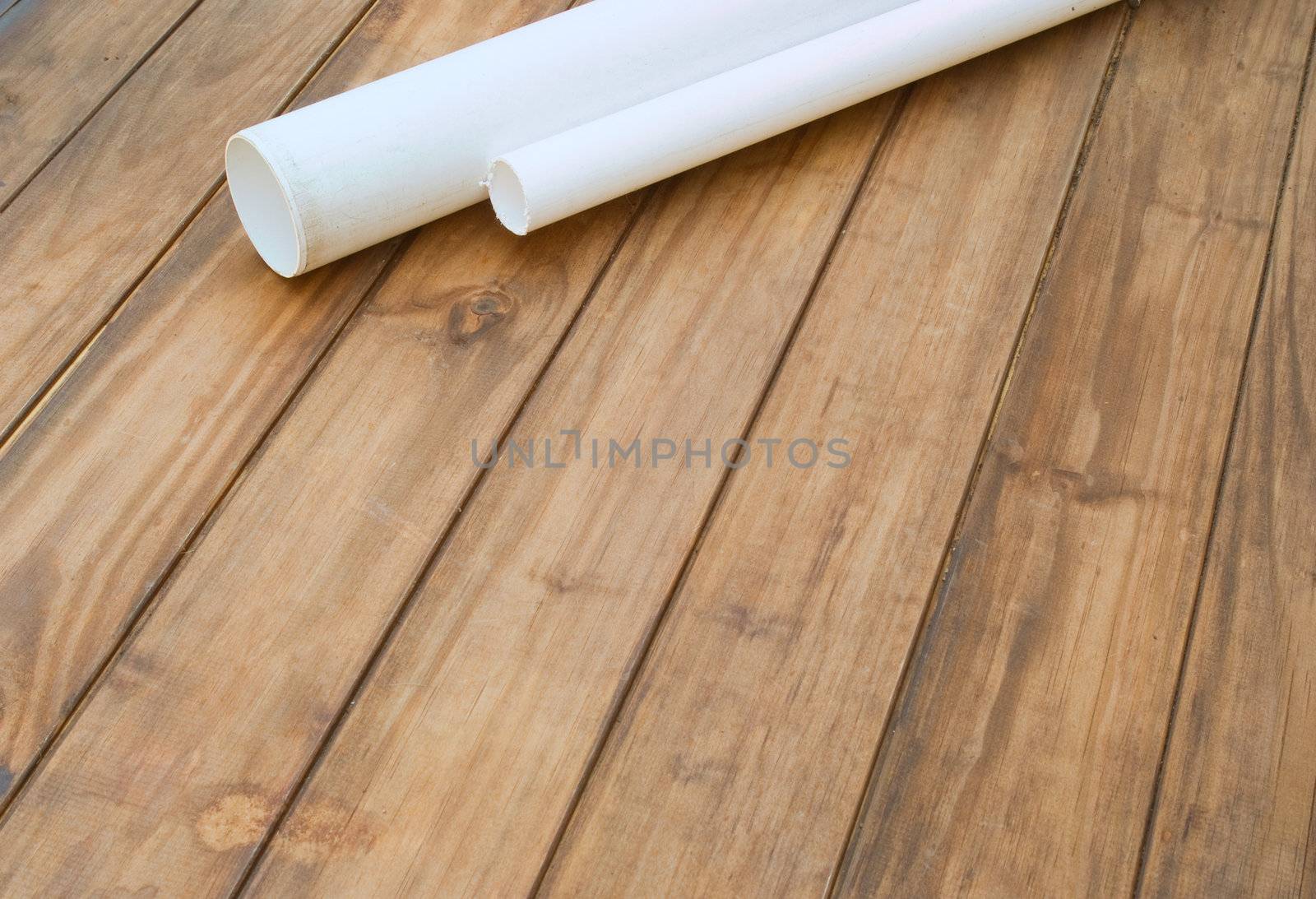 Plumbers plumbing plastic pipes on wooden work table - space for text