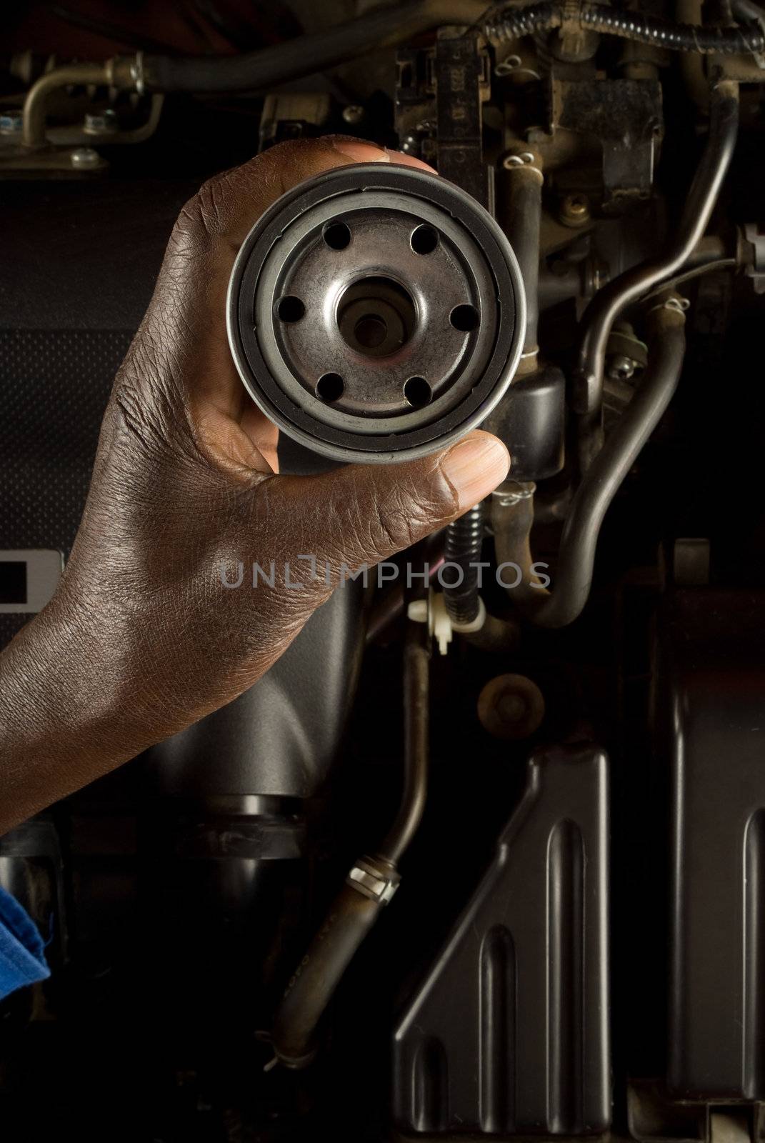 Mechanic holding oil filter by alistaircotton