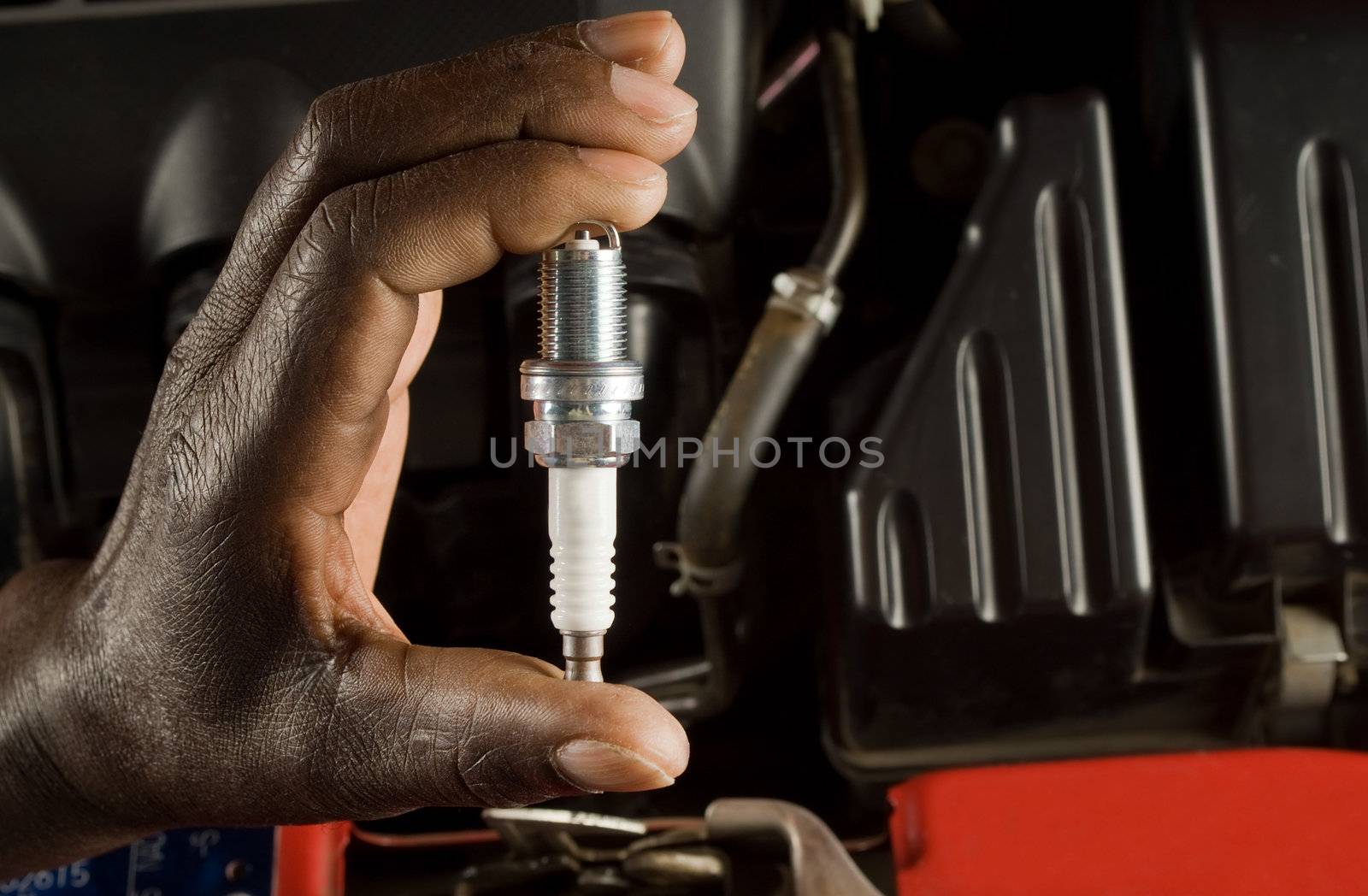 Mechanic holding spark plug by alistaircotton