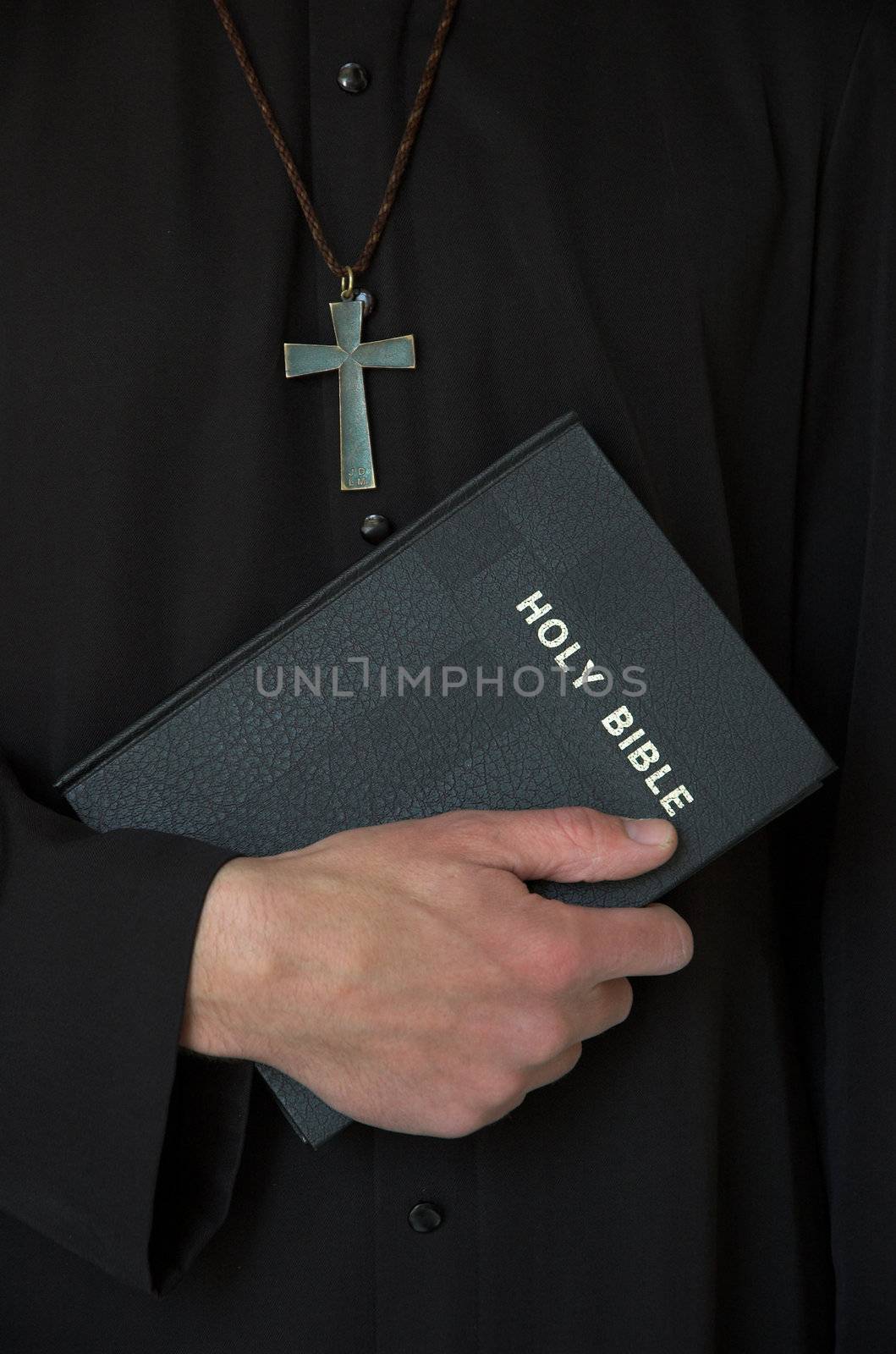 Priest holding bible with crucifix