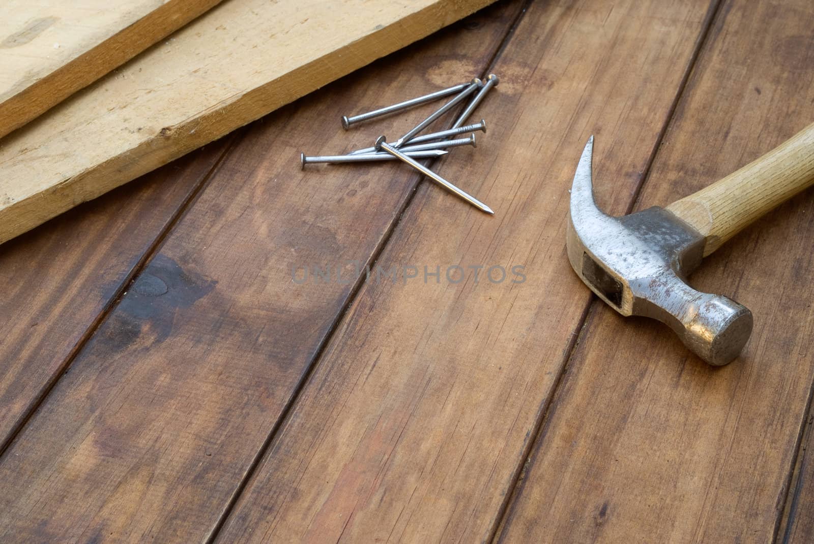 DIY hammer, nails and plank on table background