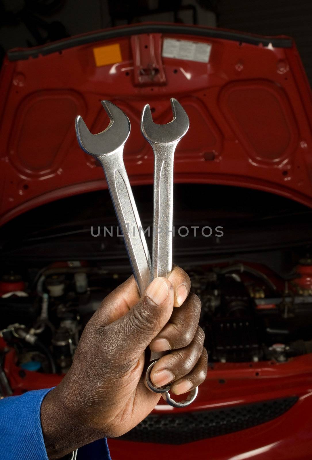 South African or American mechanic hand with spanner in front of car service engine maintenance