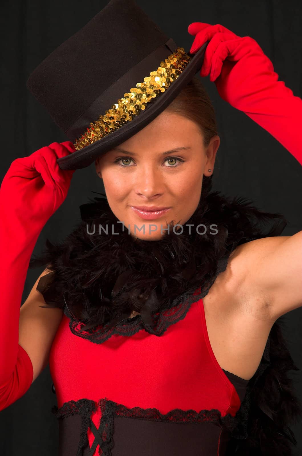 Moulin Rouge model with hat and red gloves holding hat on head with gold band