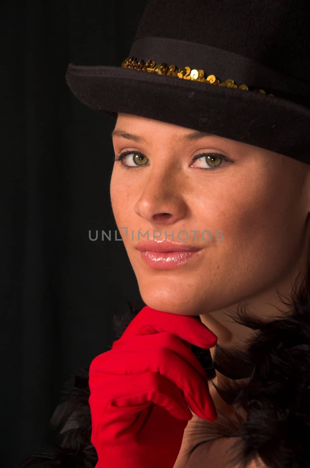 Moulin Rouge model with hat and red gloves holding hat on head with gold band and red gloves on chin