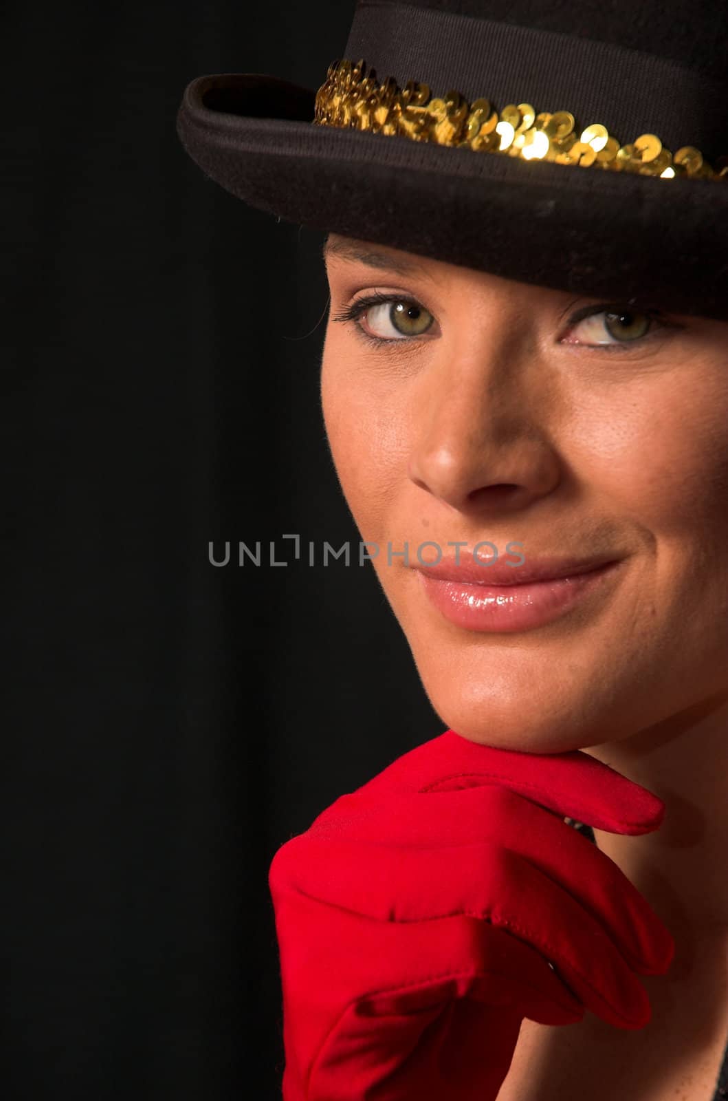 Moulin Rouge model with hat and red gloves holding hat on head with gold band and red gloves on chin