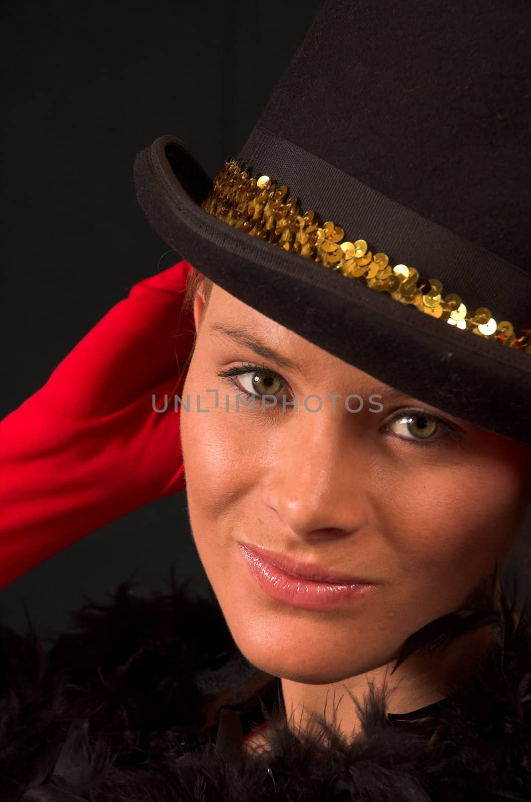 Moulin Rouge model with hat and red gloves holding hat on head with gold band and red gloves behind head