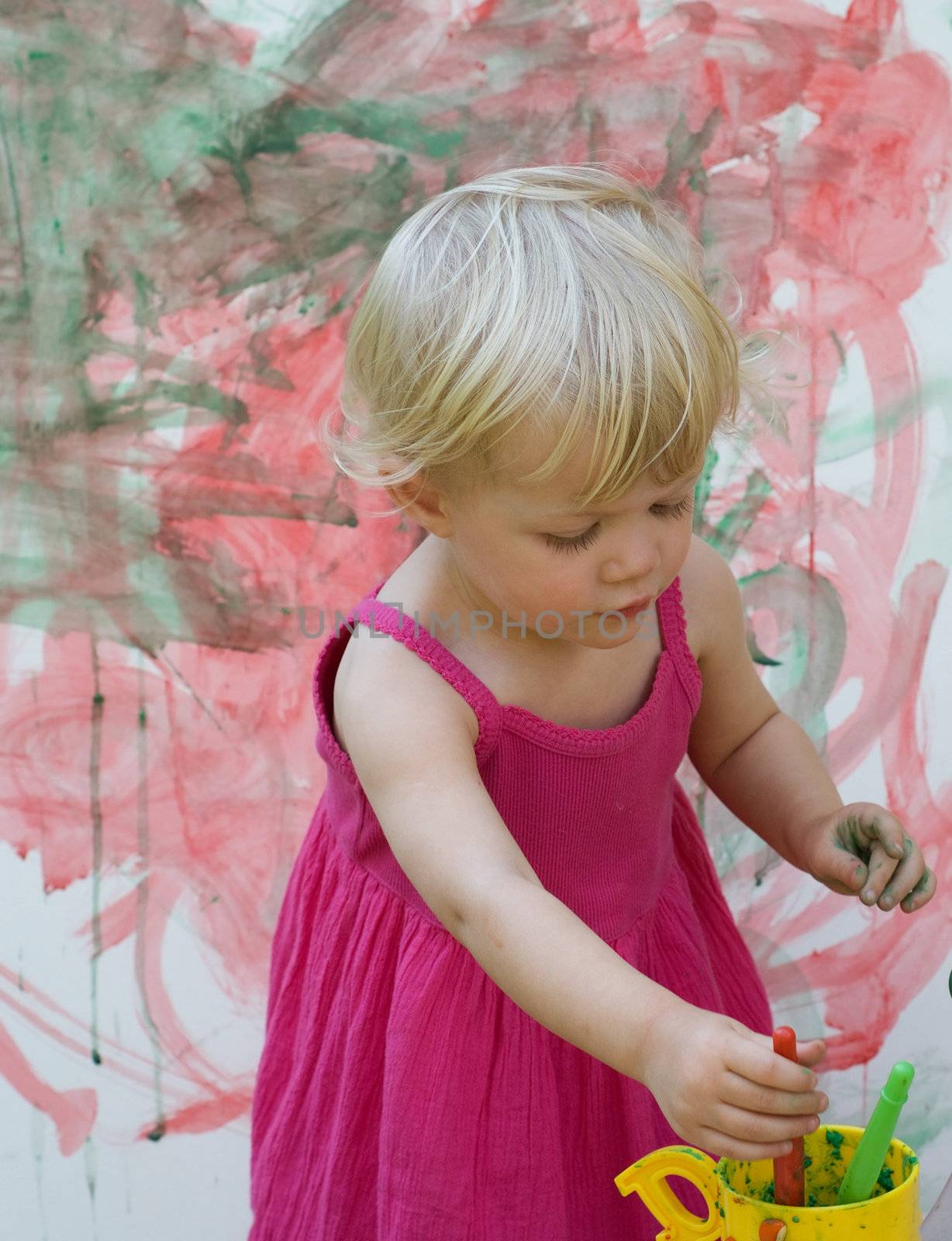 Baby little girl playing with paint artist