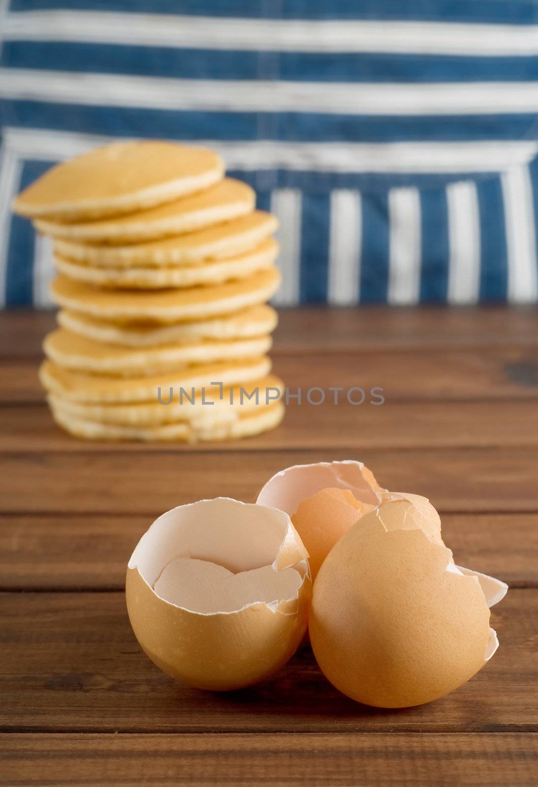 Broken egg shells with flapjacks and chef apron in background