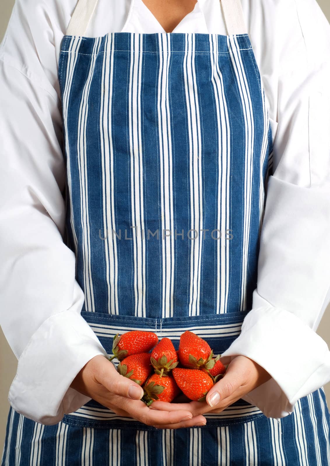 Woman chef or cook holding strawberries in her hands