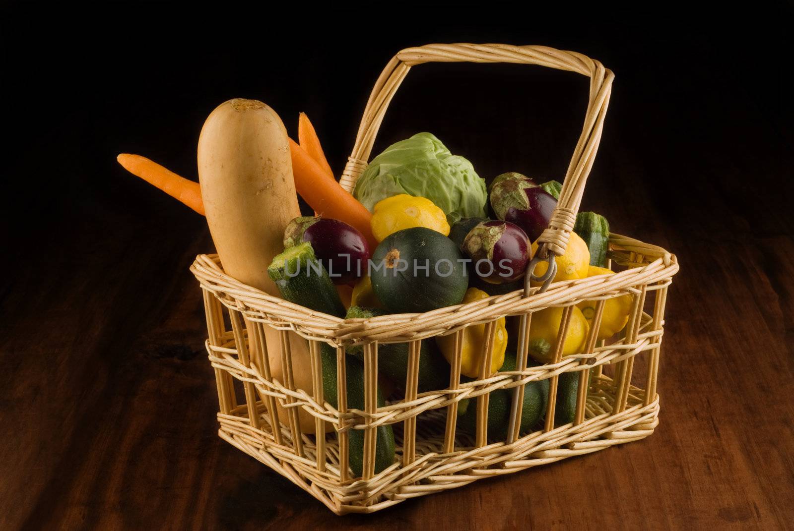 Basket of fresh farm vegetables on wooden table