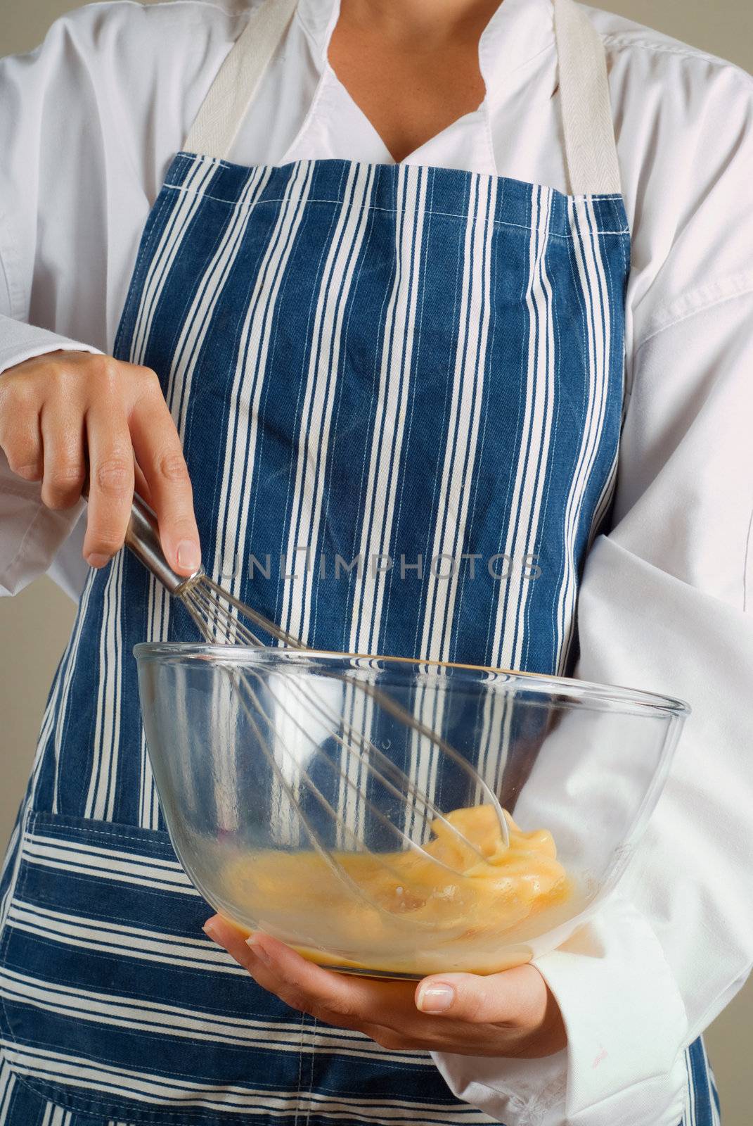 Woman chef cooking or baking stirring pancake mixture with whisk