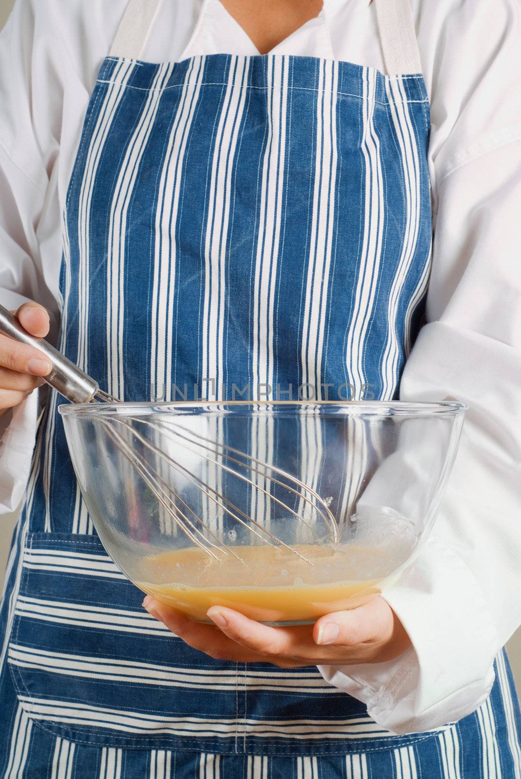 Woman chef cooking or baking stirring pancake mixture with whisk