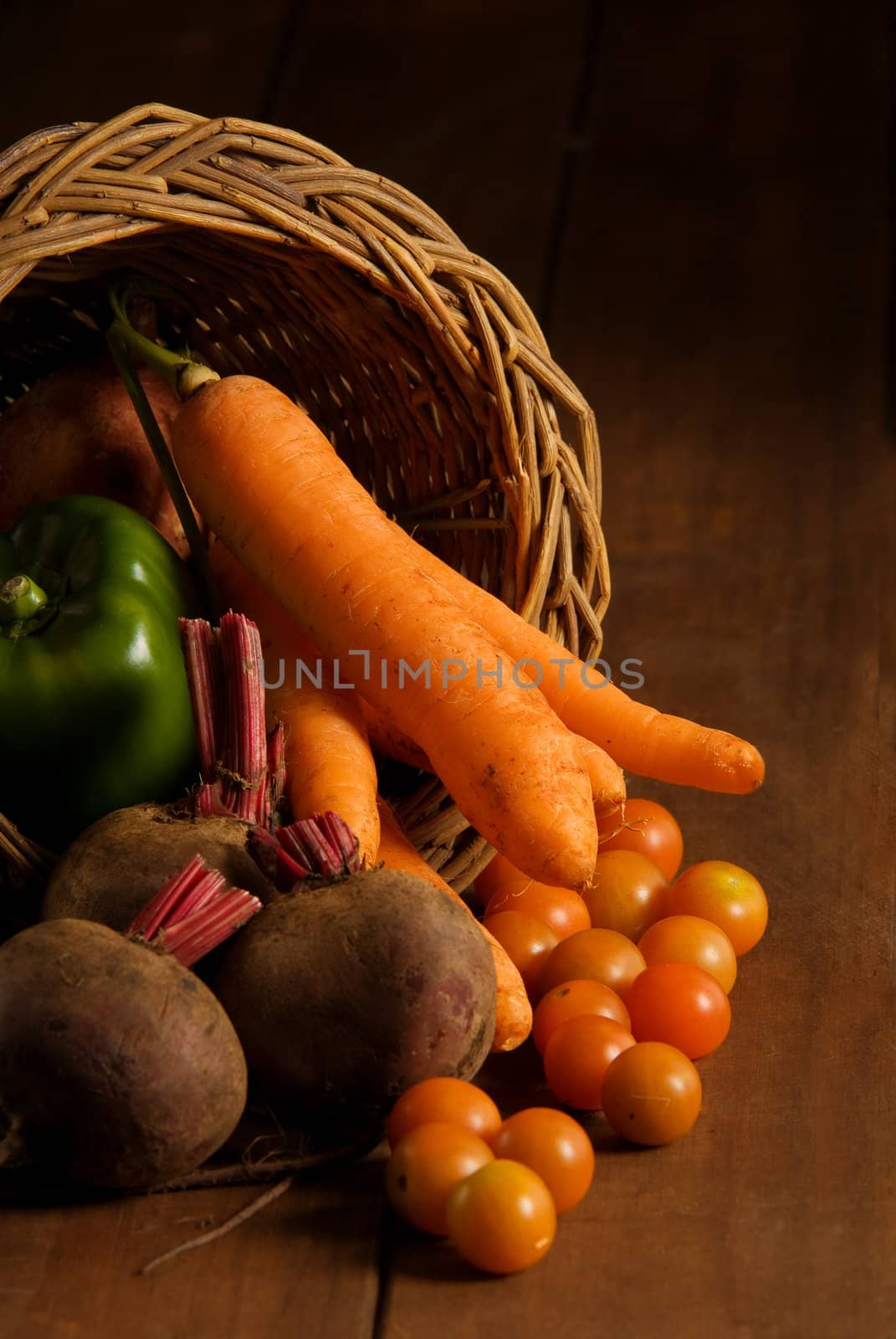 Thanksgiving cornucopia filled with autumn fruits and vegetables on wooden table.