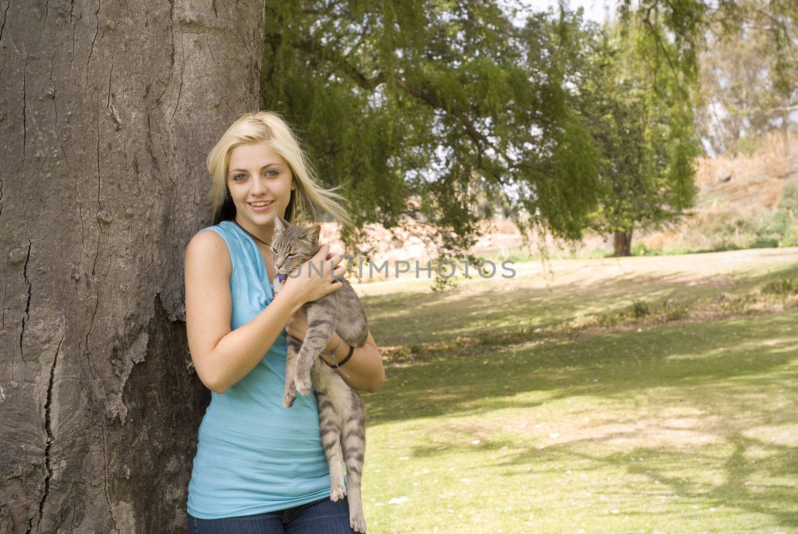 Woman or girl with pet cat in garden