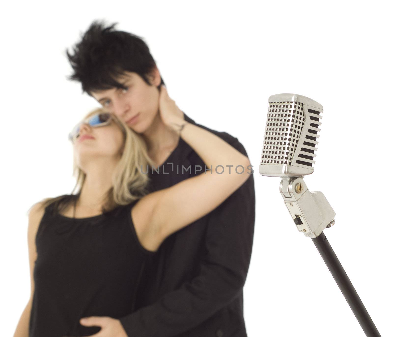 Retro singing music microphone with singers out of focus in background on white