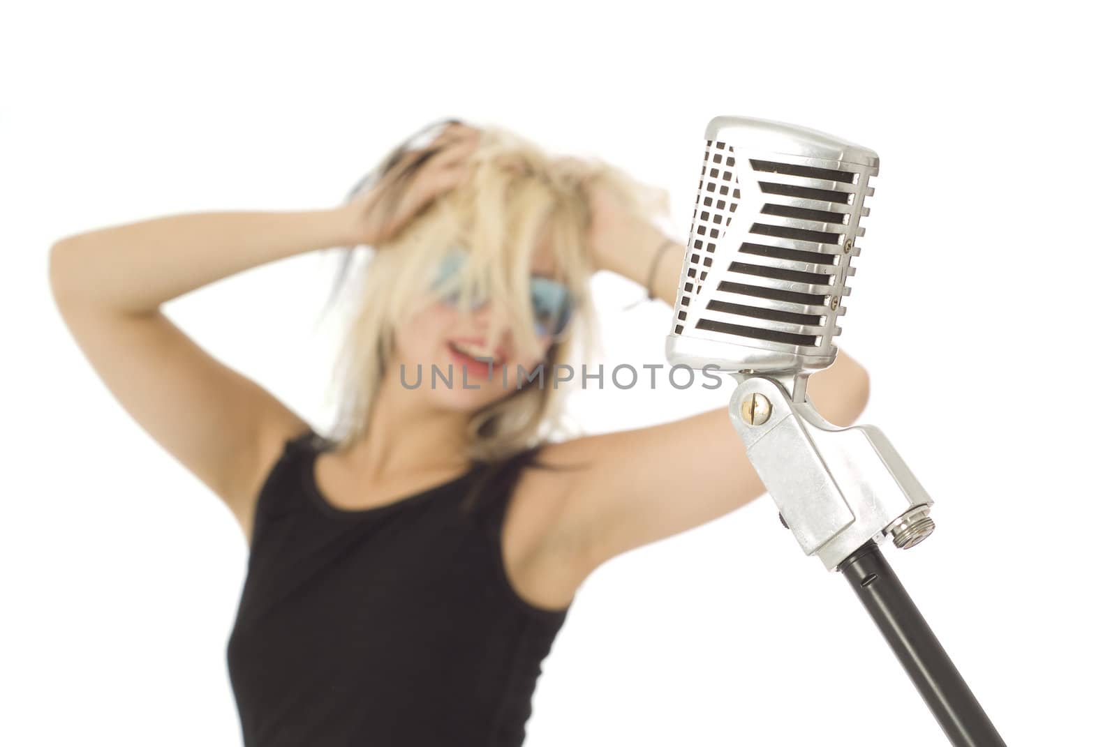 Retro microphone with rocking singer and sunglasses out of focus in background
