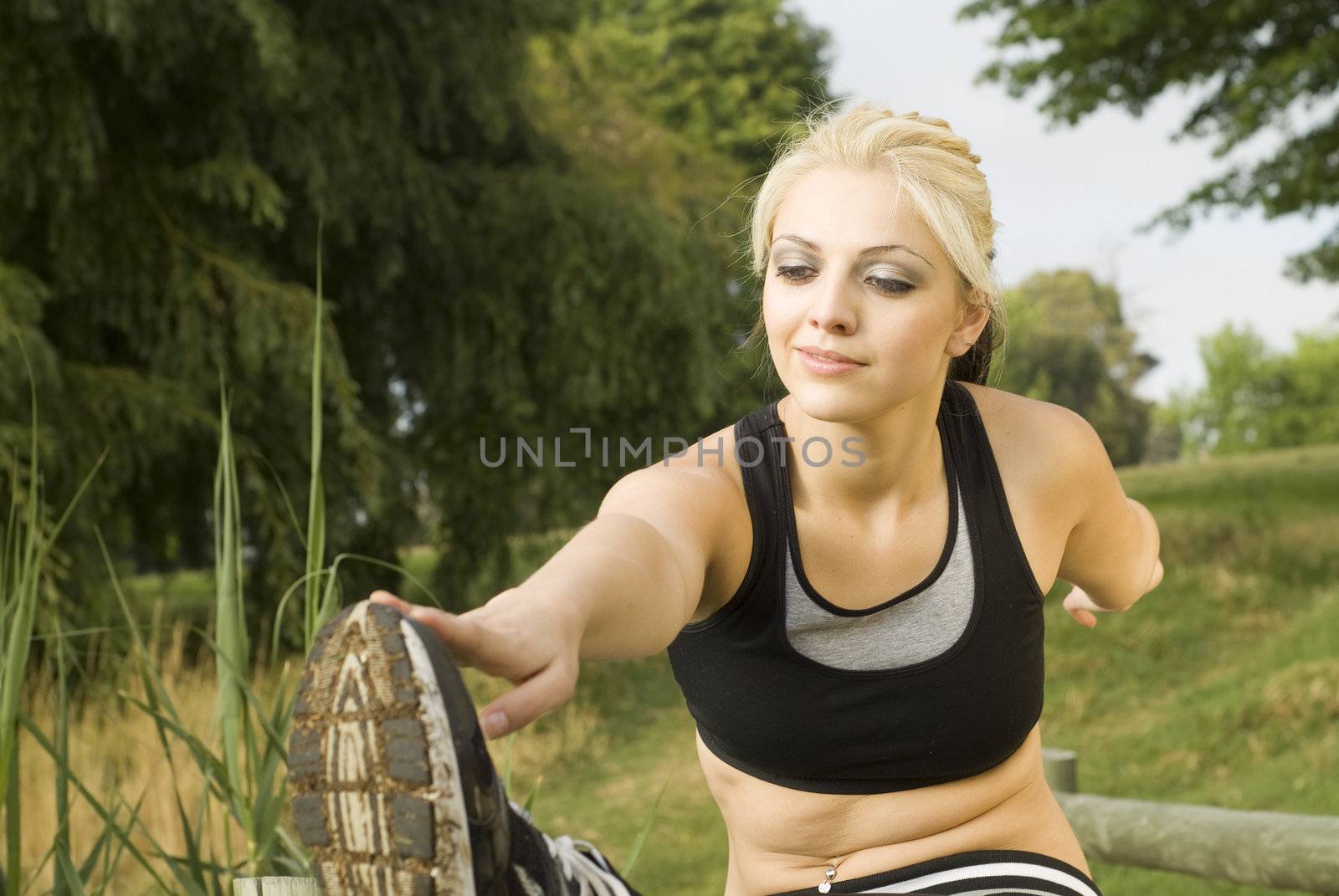 Woman runner stretching on wooden bridge