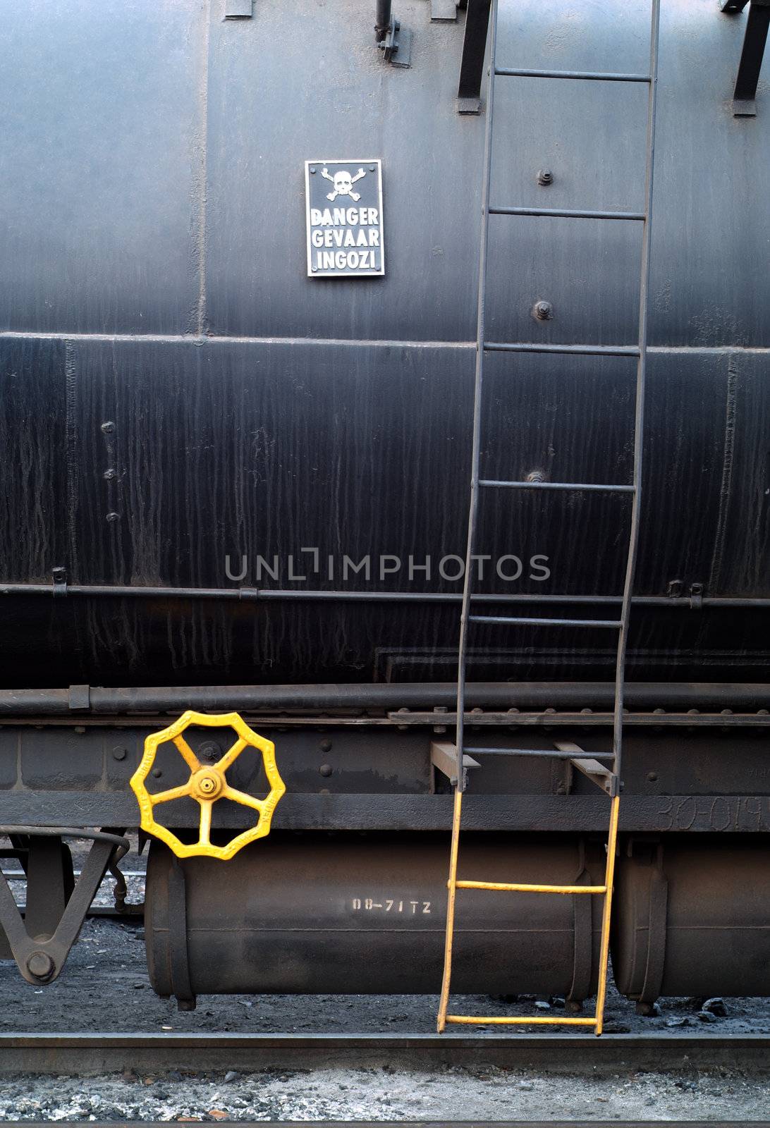 Danger sige and yellow brake wheel on side of toxic chemical railway transport carriage