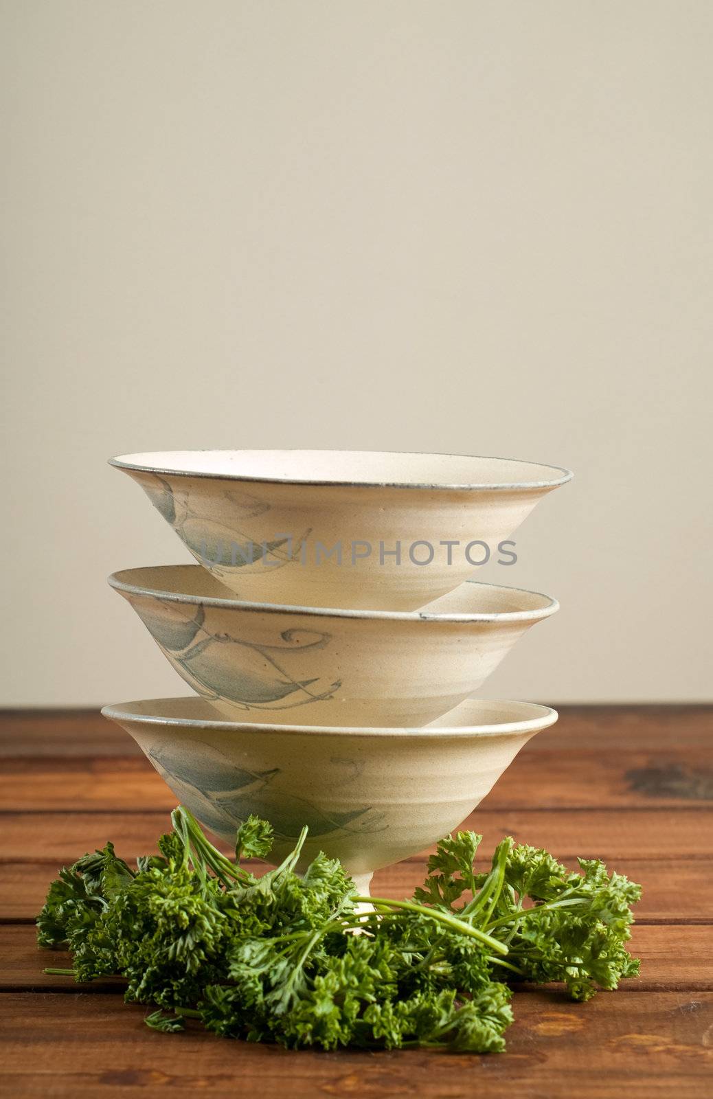 Three empty soup bowls with parsley herbs on wooden table