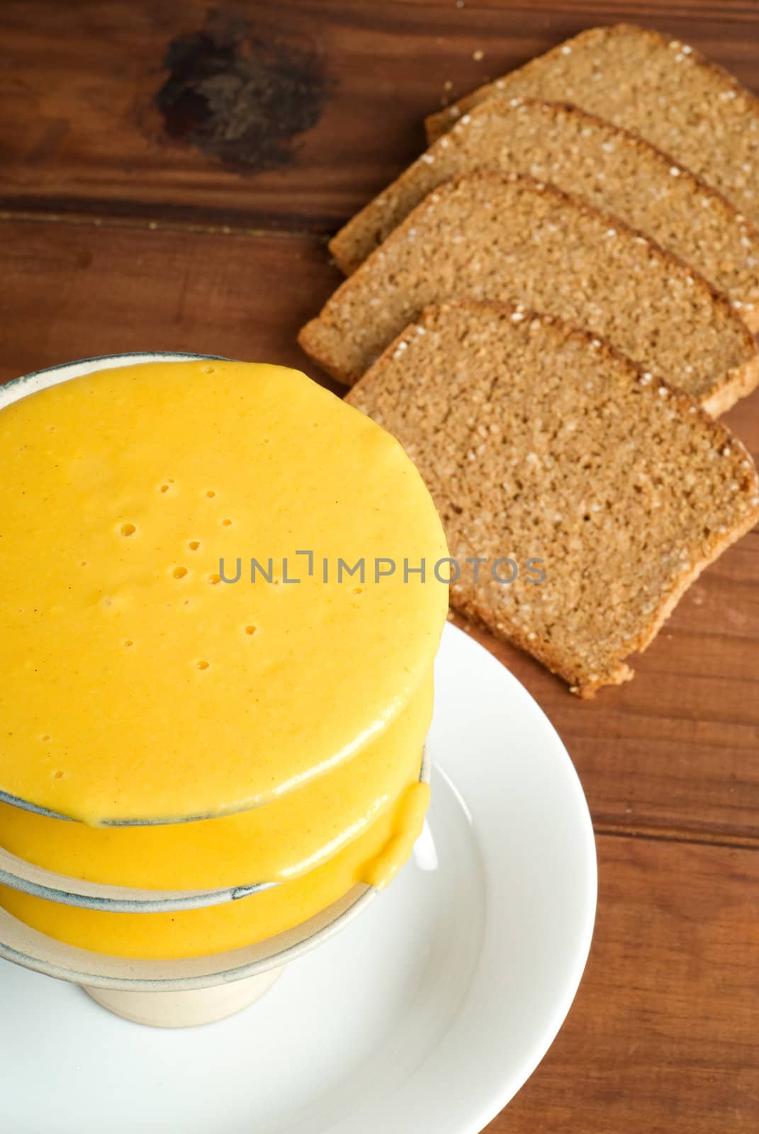 Butternut soup in bowl with rye bread in background