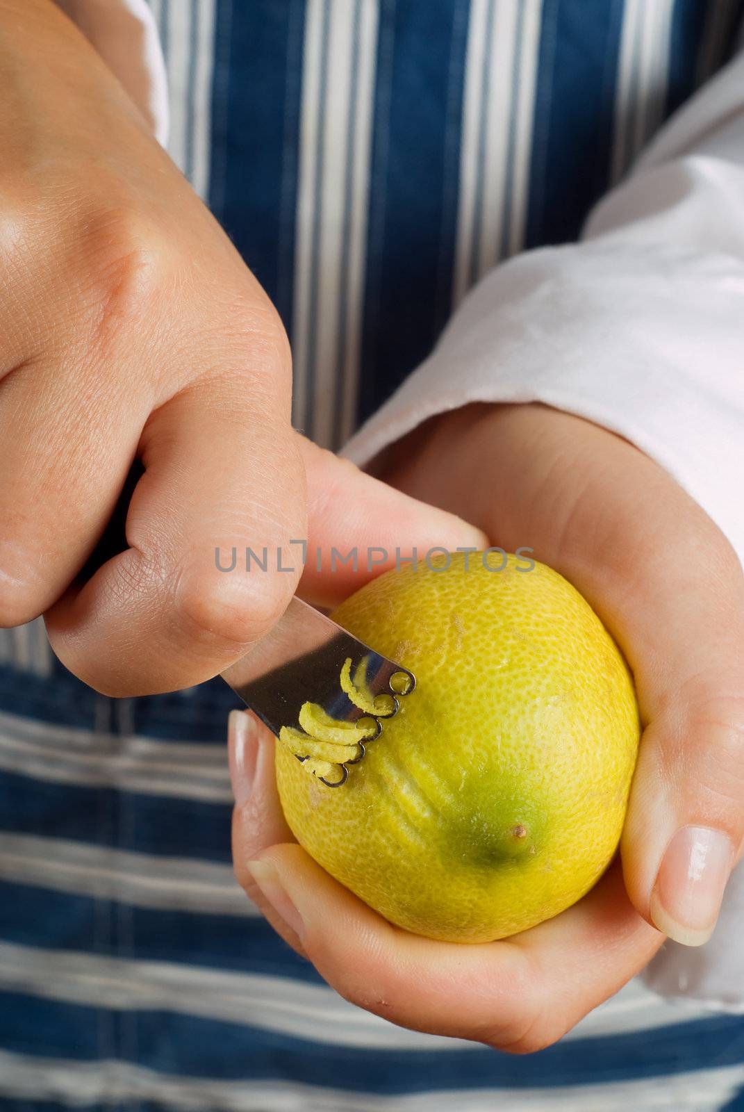 Female woman cook or chef cutting or zesting a lemon